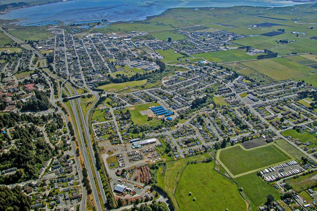 Aerial view of Arcata, California including the freeway and a large body of water